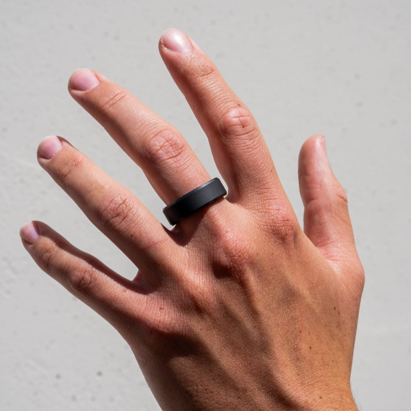 Lifestyle shot #2 of men's hands wearing our Elysium ARES solid black diamond ring | Men’s Black Diamond Rings | Black Diamond Wedding Bands | ElysiumBlack.com
