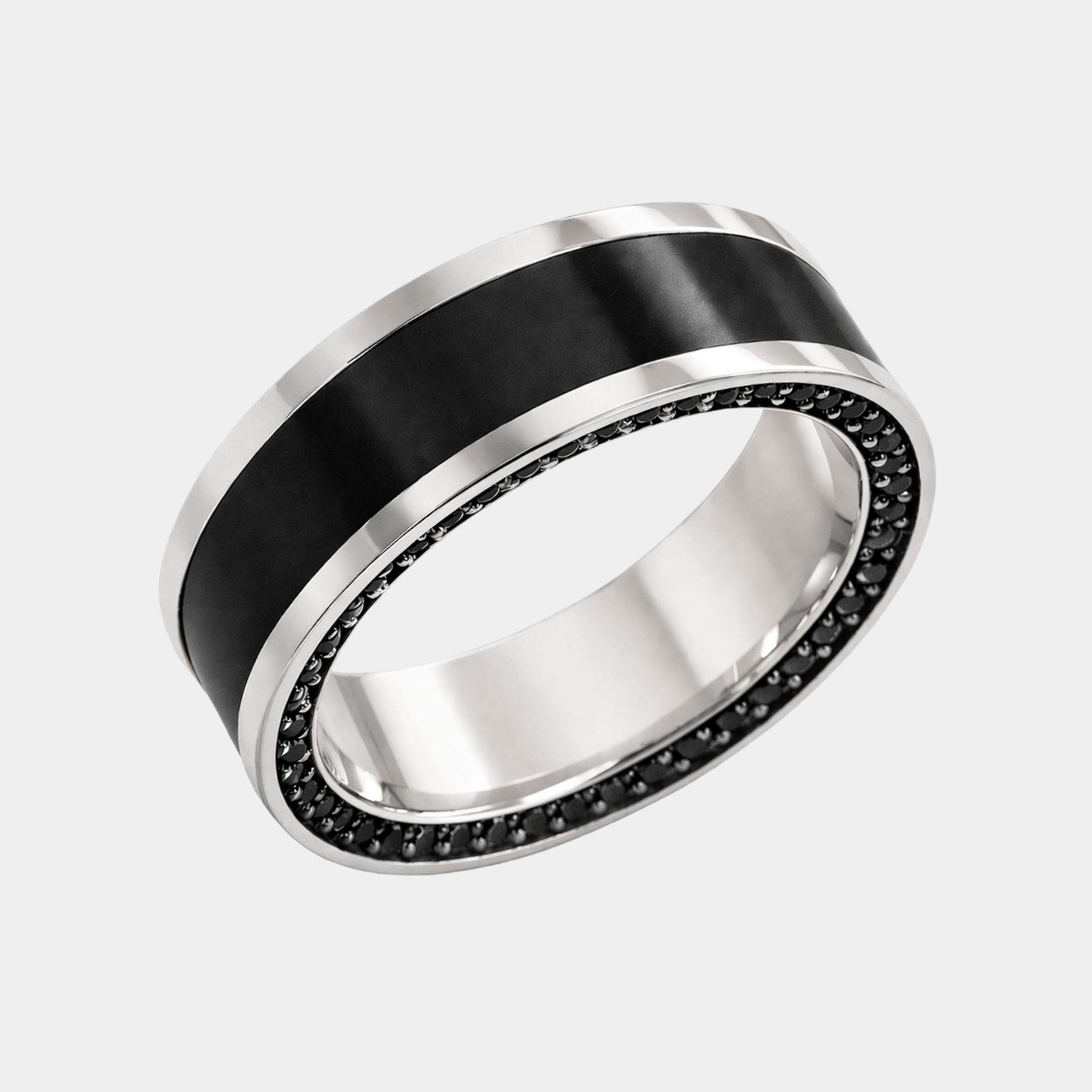 A white gold reverse inlay ring with a solid black diamond inlay and a row of small black stones around the inner edge.