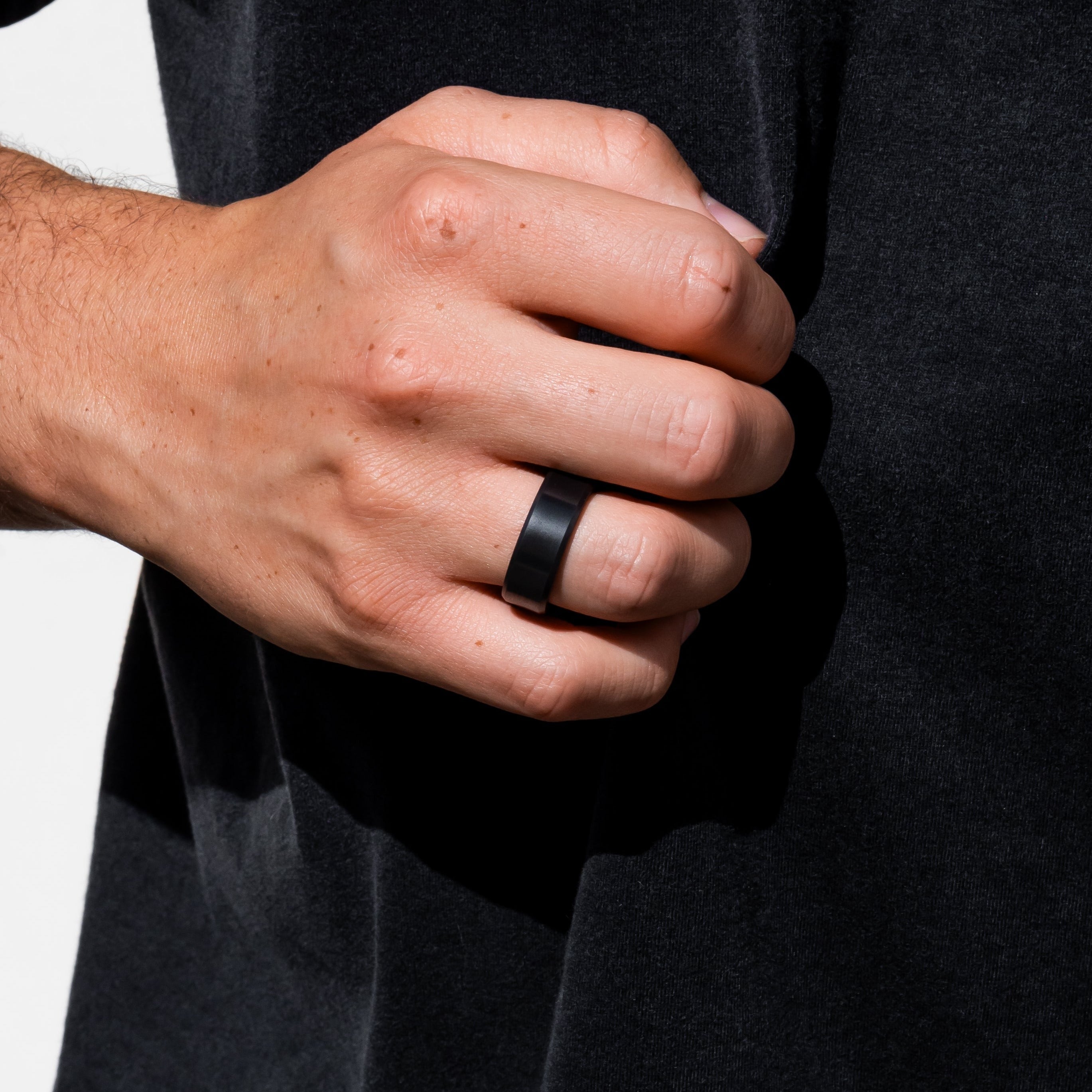 Lifestyle shot #3 of men's hands wearing our Elysium ARES solid black diamond ring | Men’s Black Diamond Rings | Black Diamond Wedding Bands | ElysiumBlack.com