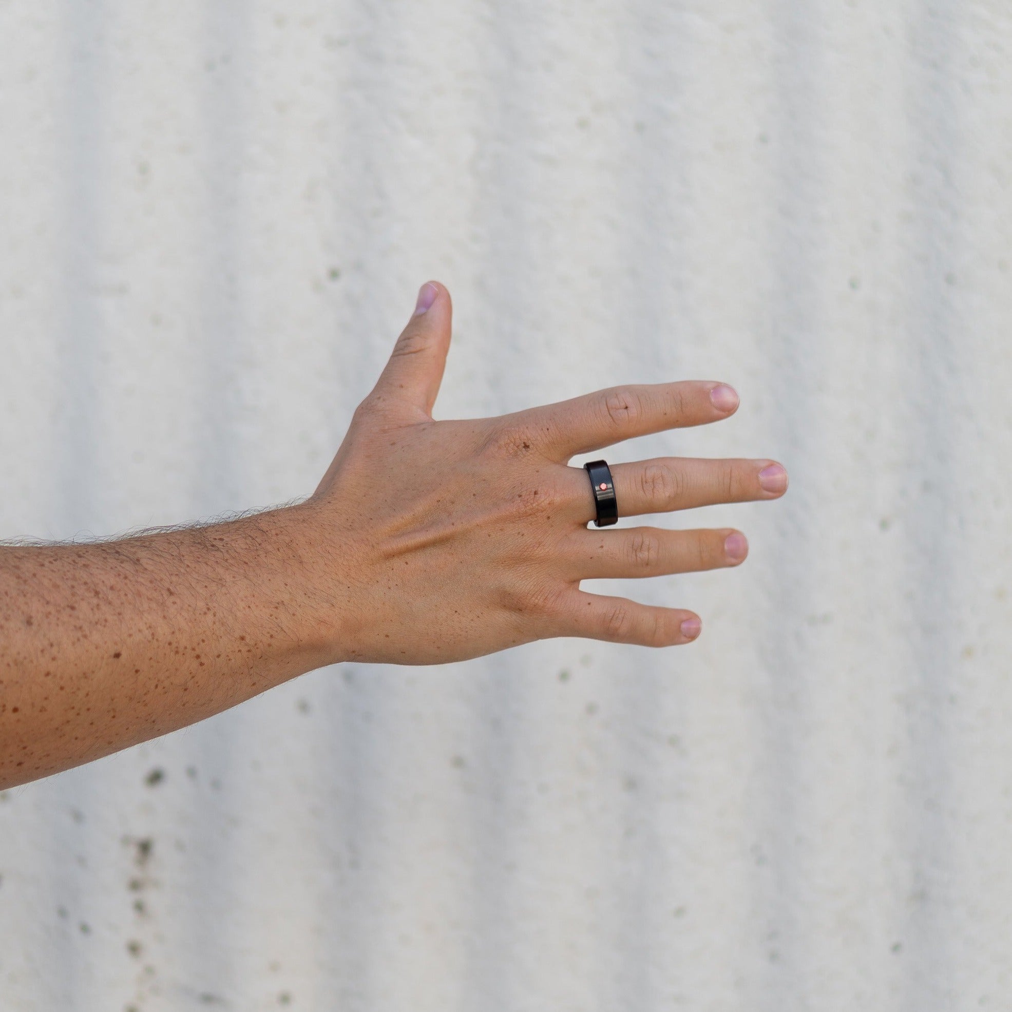 Lifestyle shot #2 of men's hands wearing our Elysium ARES Men's Black Diamond & Red Diamond Inset | ElysiumBlack.com | Men’s Red Diamond Wedding Rings