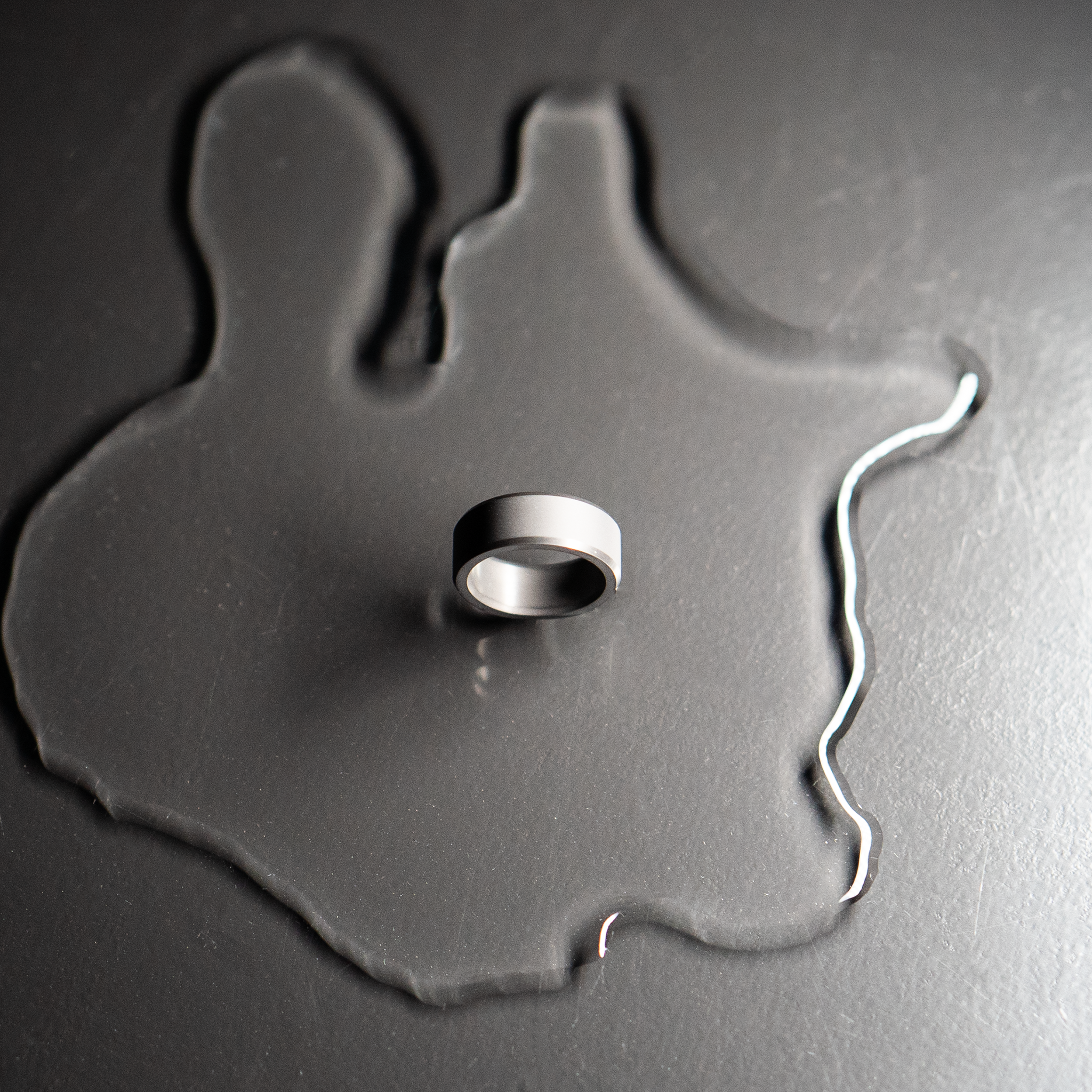 Photo of beveled matte Elysium Black Diamond Ring on water an black background