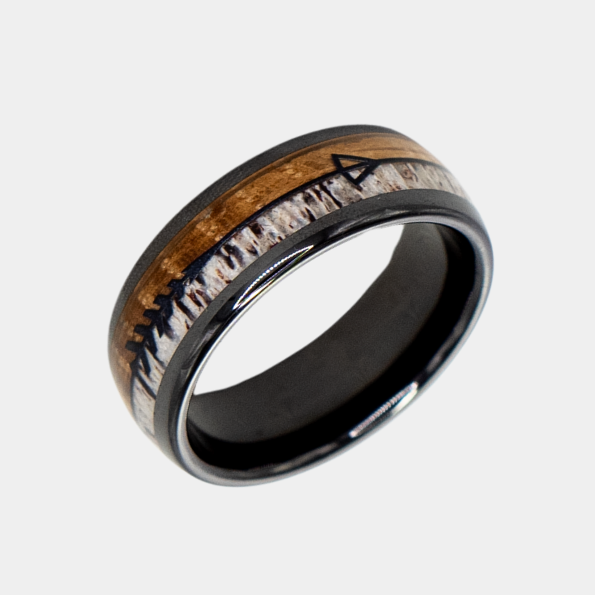 Eros ring – polished Black Ceramic featuring Whiskey Barrel Wood, Deer Antler and Black Arrow Foil part of the Hustler Collection. Angled view highlighting shape and finish.