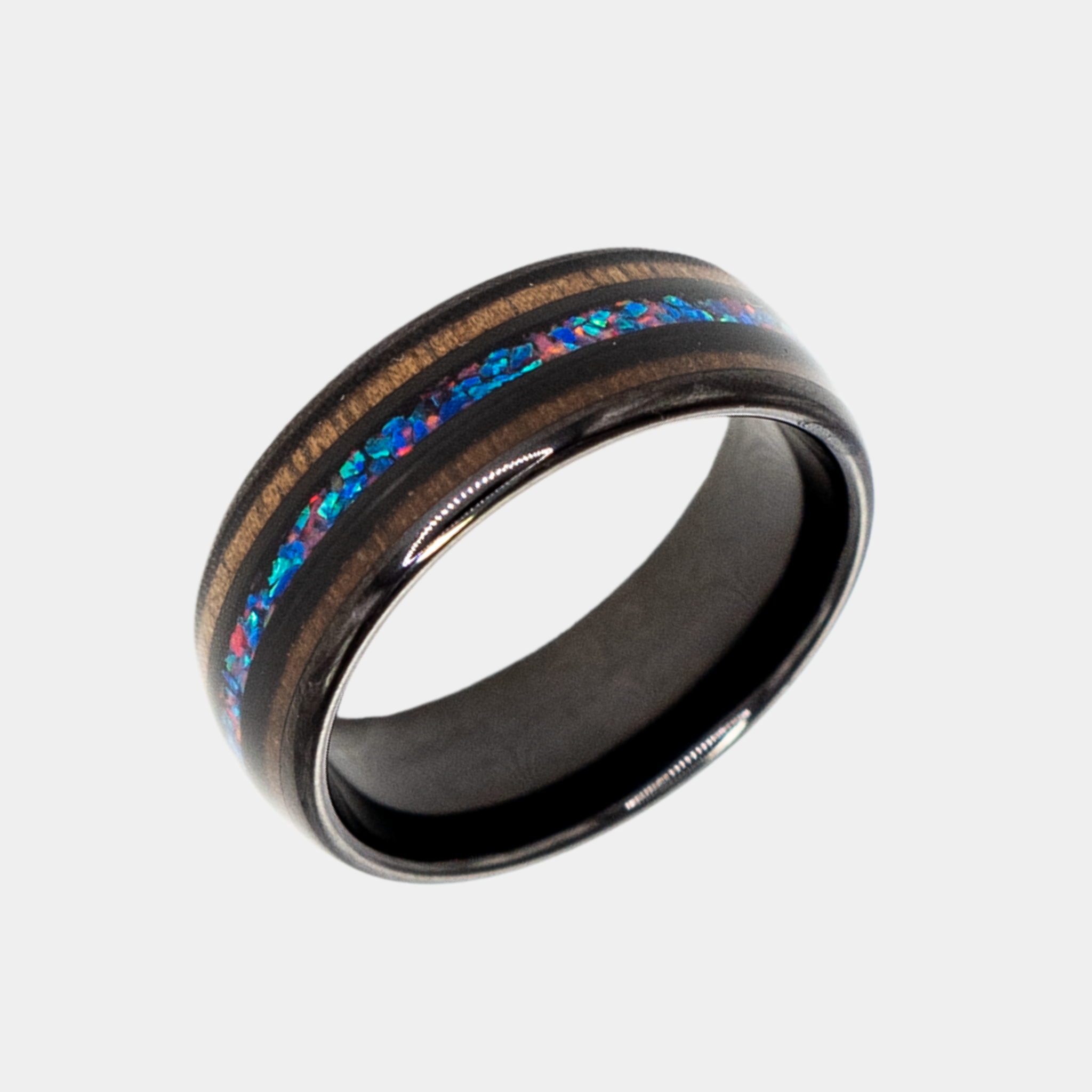 Nereus ring – Black Tungsten featuring Double Koa Wood and Crushed Opal Inlays from the Hustler Collection. Angled view highlighting shape and finish.