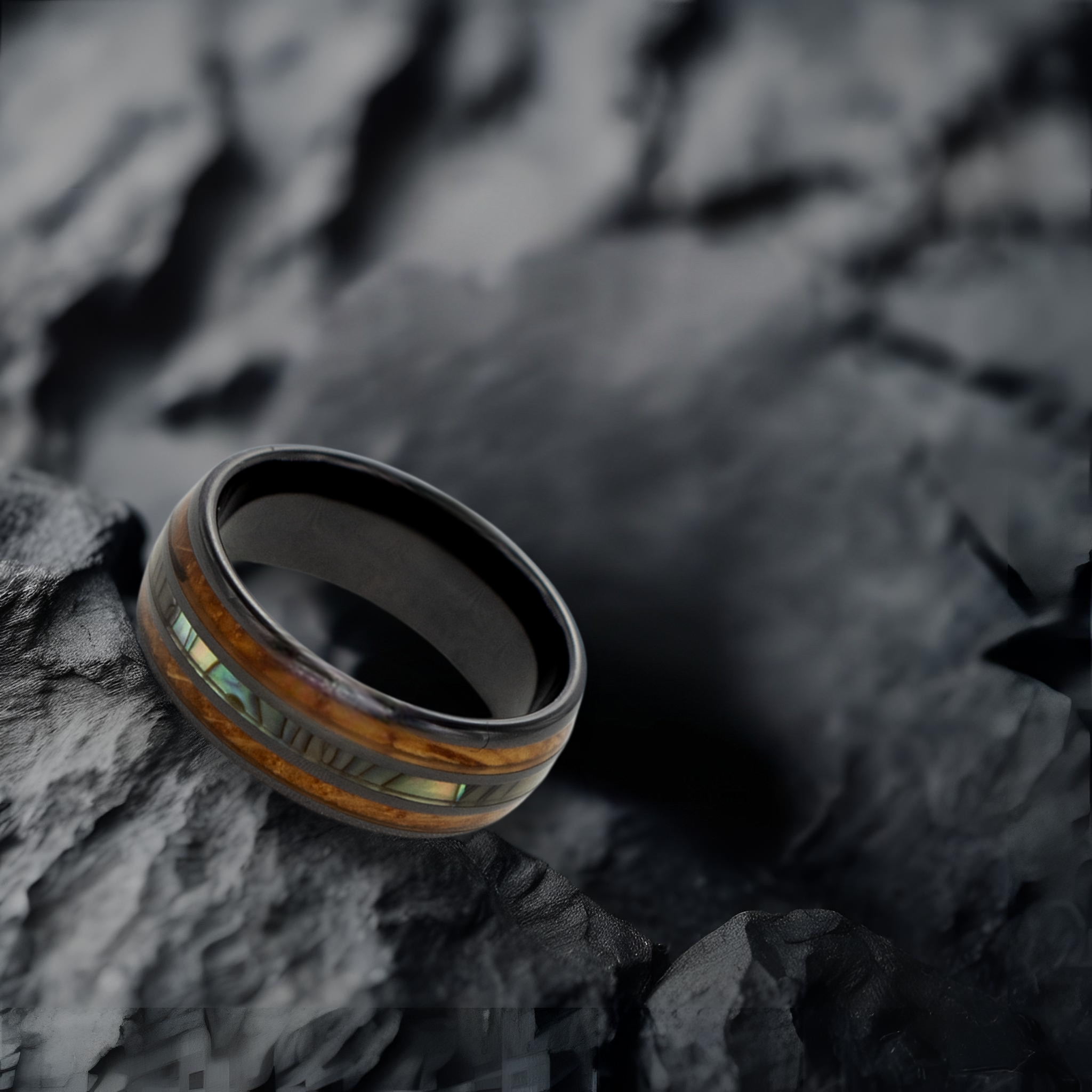 Odysseus ring – solid black diamond with polished beveled edges from the Hustler Collection. Lifestyle shot, placed on textured rock.