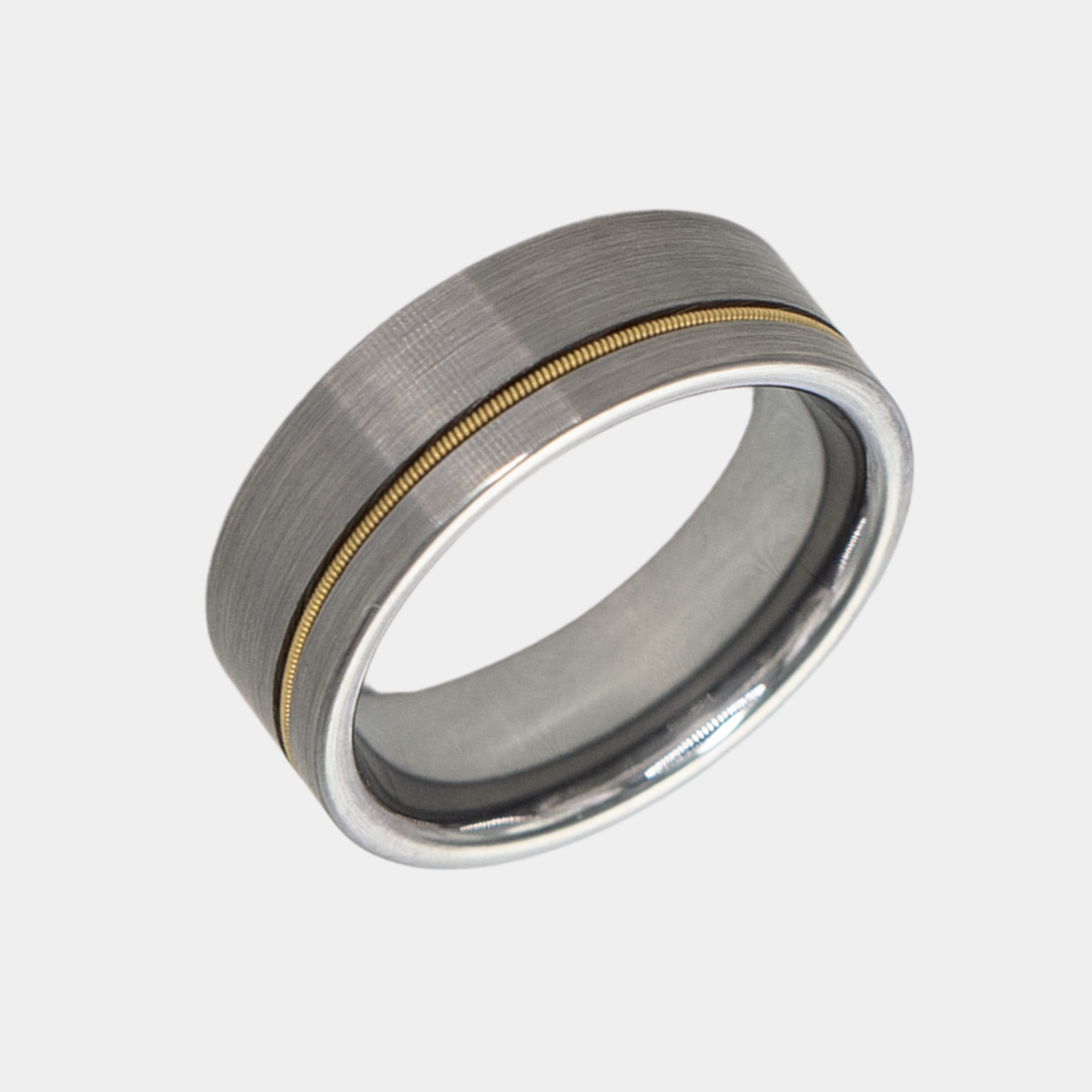 Orpheus ring – Brushed Silver Tungsten with Gold Guitar String Inlay from The Hustler Collection. Angled view highlighting shape and finish.