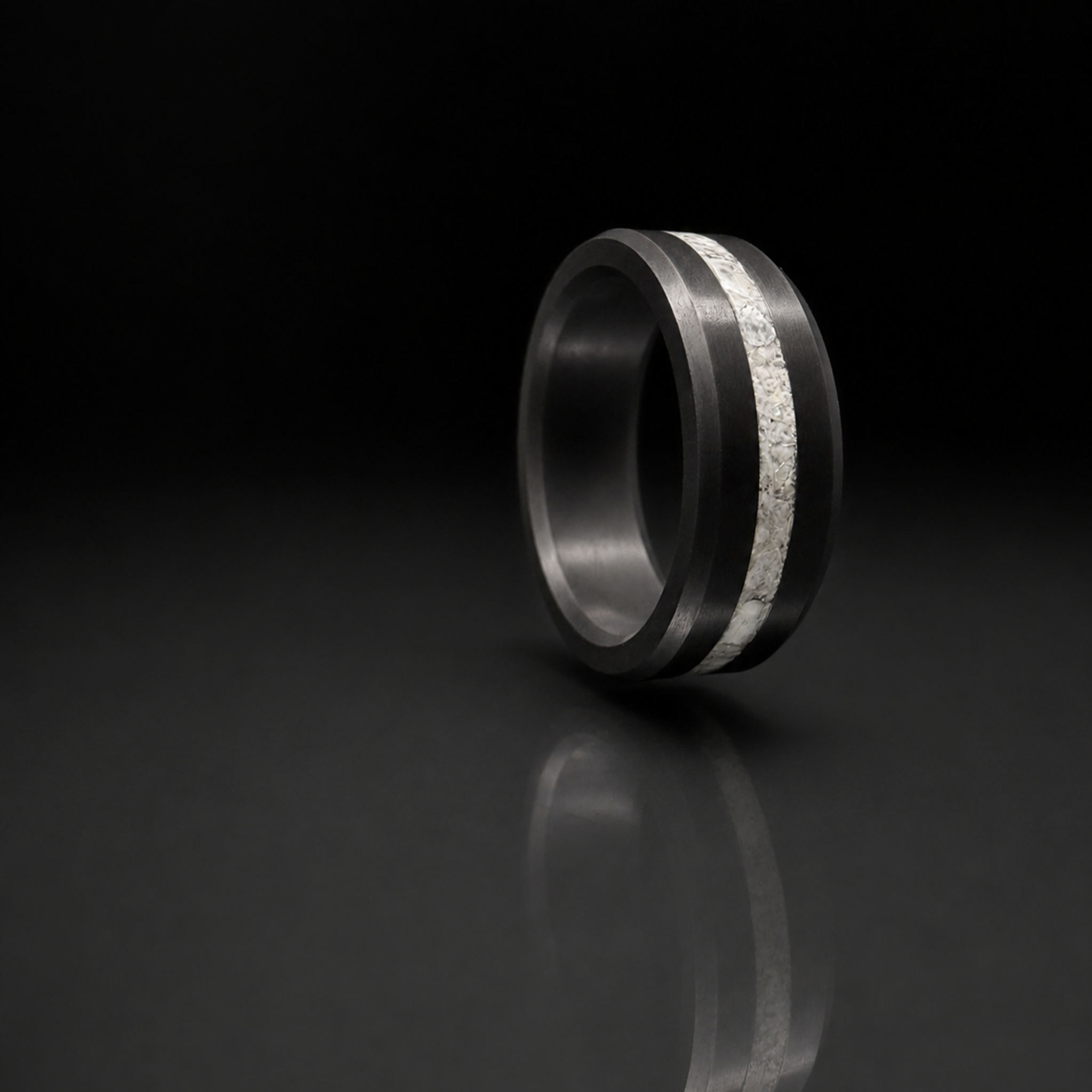 ARES crushed pearl inlay ring in solid black diamond on dark editorial surface