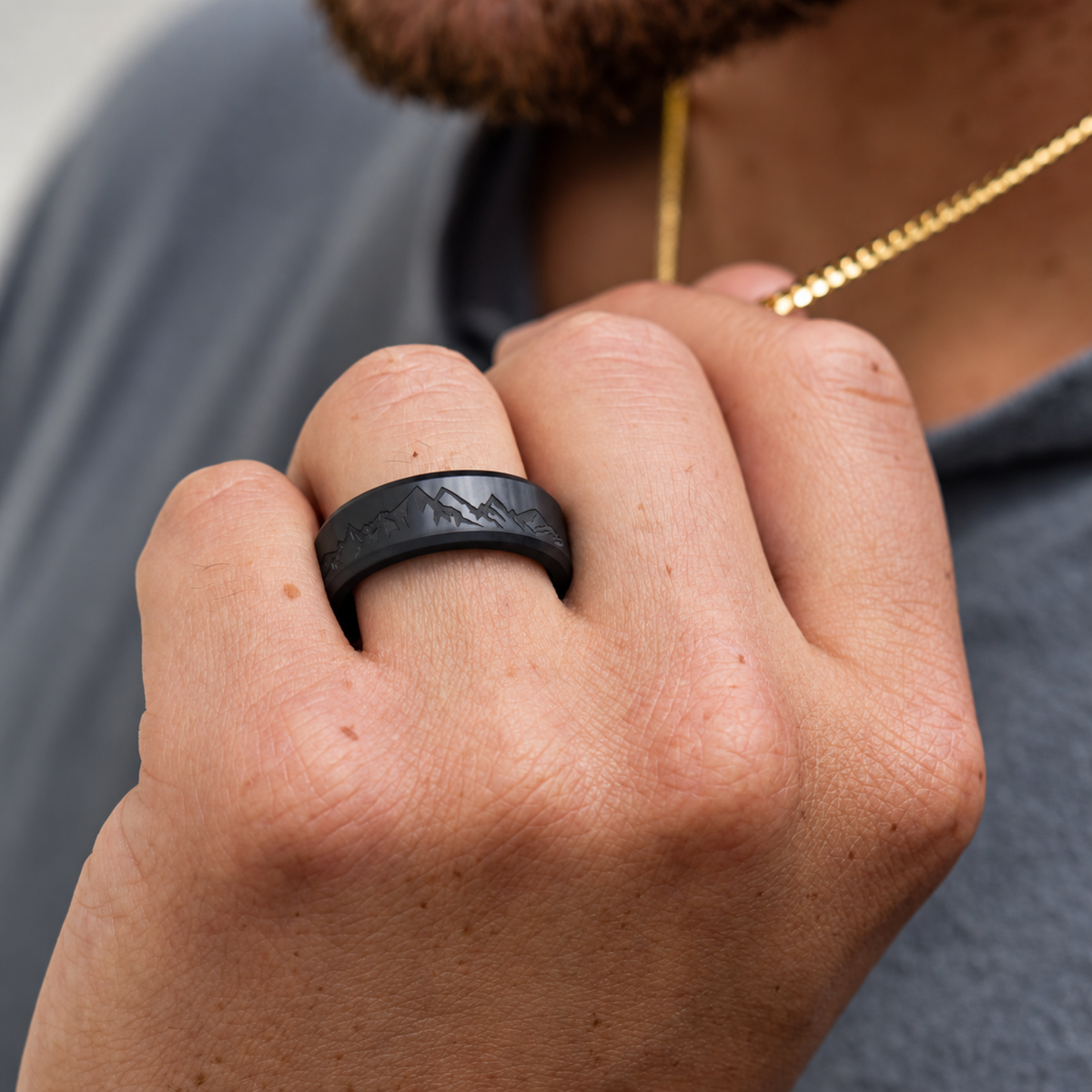 ARES solid black diamond ring worn on a hand, showing an example laser-engraved mountain range.